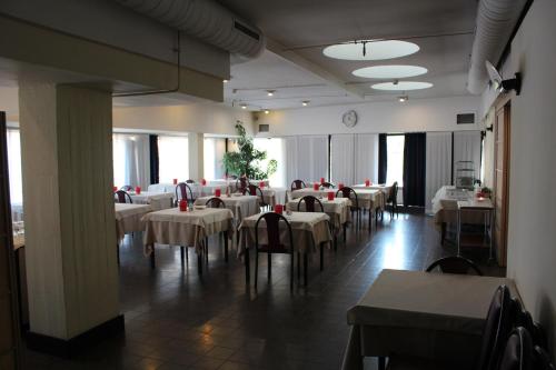 代西奥赛莱德酒店的一间配备有白色桌椅和时钟的餐厅