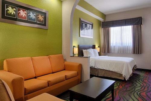 博尼塔斯普林斯Days Inn & Suites by Wyndham Bonita Springs North Naples的酒店客房,配有床和沙发