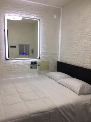 芝加哥Hotel BnB-1的卧室配有一张带镜子的白色床