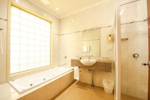 斯特拉萨尔宾斯特拉斯汽车旅馆的带浴缸、水槽和浴缸的浴室