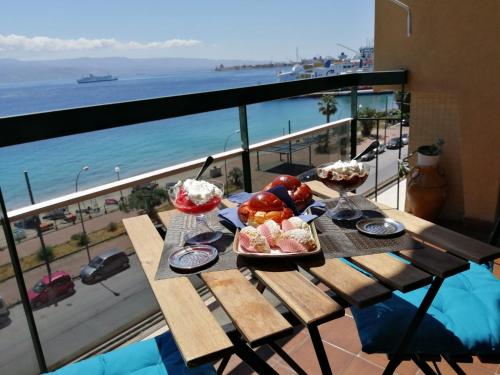 墨西拿The door of Sicily的一张桌子,上面有食物,享有海景