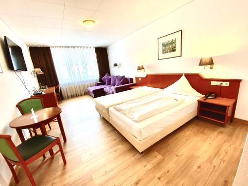 拉芬斯堡加尼利格尔顿酒店的酒店客房带一张床、一张桌子和椅子