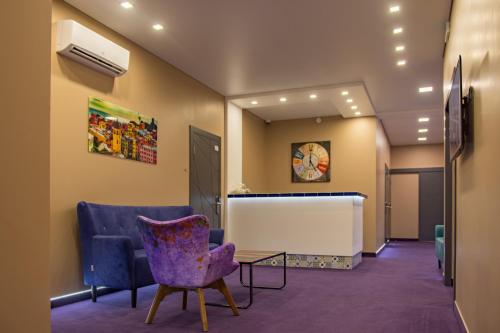 敖德萨Horizon Hotel的一间设有紫色椅子和桌子的等候室