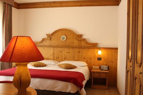 库马约尔Hotel Vallée Blanche Courmayeur的一间卧室配有一张床,上面有灯