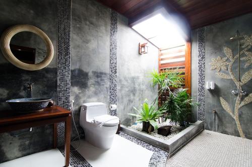 Damnoen Saduak麦克瓦达莫恩度假酒店的浴室设有卫生间和植物