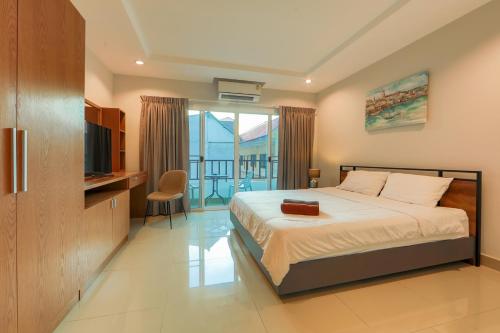 芭堤雅市中心Nalanta Hotel Pattaya的一间卧室设有一张带电视的床和一个阳台。