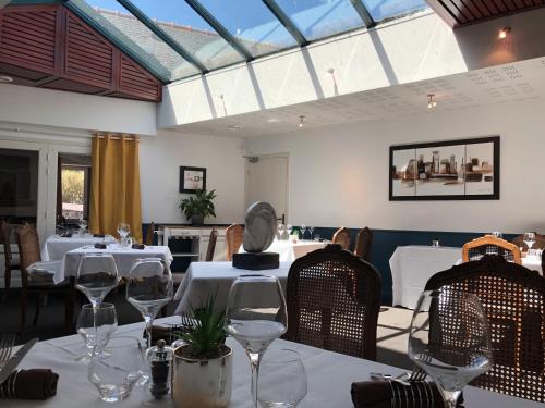 圣泰戈内克圣图格讷克客栈的用餐室配有白色的桌椅和玻璃杯