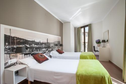 巴塞罗那BCNGOTIC 41的酒店客房设有两张床,墙上挂有绘画作品