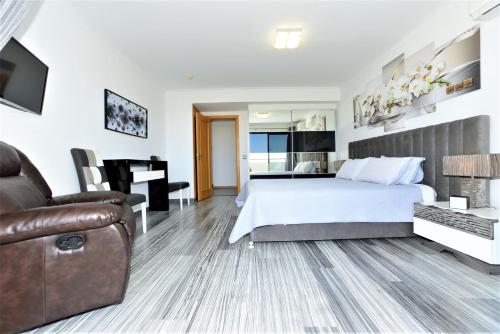 波尔蒂芒Exclusive Luxury Apartments in Oceano Atlantico Complex的酒店客房,配有床和沙发