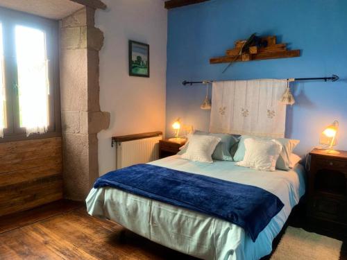 Ziga波萨达泽加旅馆的一间卧室配有一张蓝色墙壁的床和一扇窗户