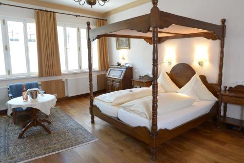 丁克尔斯比尔杜特斯彻斯豪斯酒店的一间卧室配有一张天蓬床和一张桌子