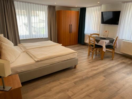 巴特迪尔海姆伽斯特翰斯基瑟拉酒店的一间卧室配有一张床、一张桌子和一台电视
