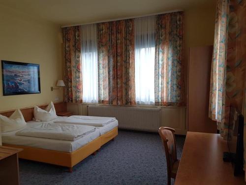 费尔巴赫Traube Hotel Oeffingen的酒店客房设有两张床和窗户。