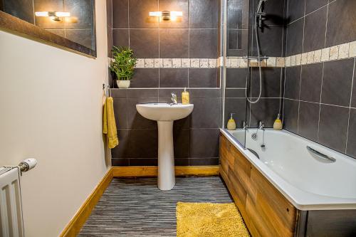 因弗内斯Modern 2 bedroom garden flat的浴室配有盥洗盆和浴缸。