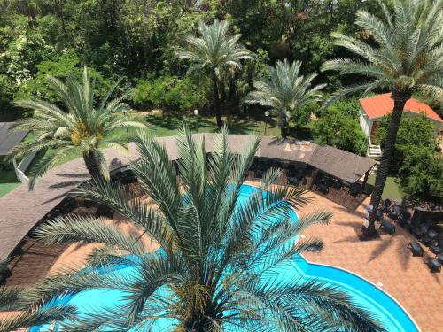 提比里亚瑞斯泰尔酒店的享有带游泳池和棕榈树的度假村的顶部景致