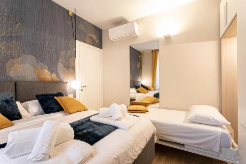 摩德纳casapalestro8#2的一间卧室配有两张带白色床单和黄色枕头的床。
