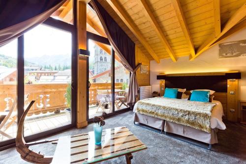 拉克吕萨Les Airelles的一间卧室设有一张床和一个大窗户