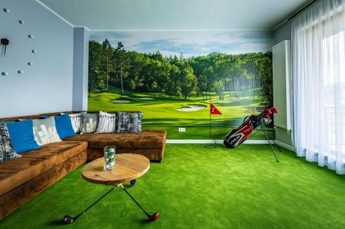 克卢日-纳波卡The Golfer Apartment with Jacuzzi的客厅里画着高尔夫球场的画作