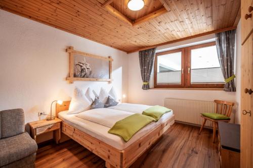齐勒河谷采尔Haus Gatterland的卧室配有床、椅子和窗户。
