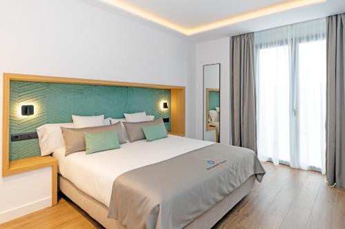阿达莱斯Apartamentos Ardales Premium的卧室配有一张带绿色床头板的大型白色床