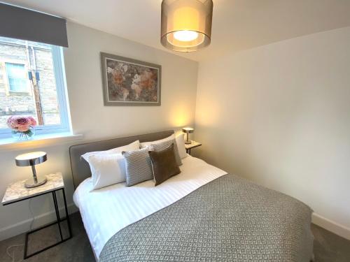 珀斯High Street, Stylish City Centre Apartment, 3 Bed的卧室配有带枕头的床铺和窗户。