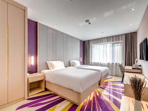 天津Lavande Hotel Tianjin Joy City Gulou Subway Station的卧室配有一张白色大床和紫色墙壁