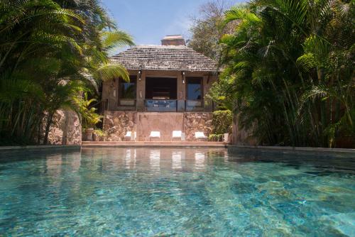 蓬塔米塔蓬德美达伊玛塔度假酒店的棕榈树屋前的游泳池