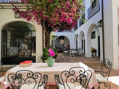 埃尔罗西奥林塞卡萨乡村酒店的天井上配有带粉红色鲜花的桌椅