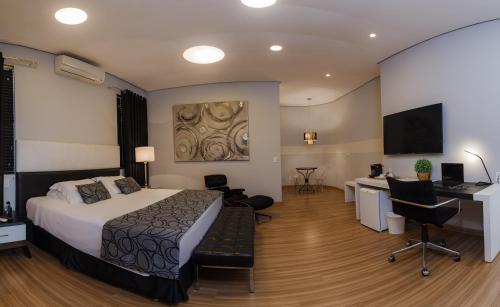 卡塔洛Mara Turismo Hotel的酒店客房配有一张床、一张书桌和一台电视。