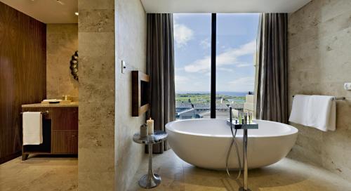 乔治奥巴艾高尔夫和Spa度假村的带浴缸的浴室和大窗户
