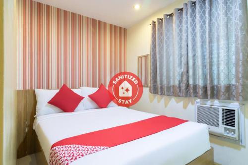 马尼拉Starlight Bed and Breakfast的一间卧室配有红色和白色枕头的床