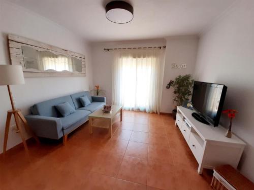 塔里法Encanto de Tarifa的客厅配有蓝色的沙发和电视