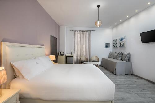 干尼亚Shalom Luxury Rooms Daliani的白色卧室设有一张大床和一张沙发