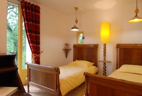 拉罗克叙尔佩尔讷La maison jaune的一间卧室设有两张床和窗户。