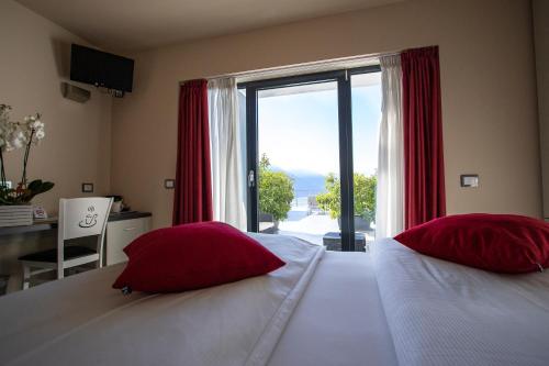 滕诺阿格里特瑞斯特里美食与放松酒店的一间卧室配有两张带红色枕头的床和窗户。