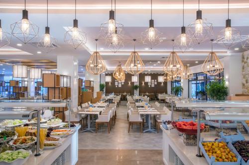 阿萨拉尔Numa Bay Exclusive Hotel - Ultra All Inclusive的餐厅的用餐室的景色,餐桌上摆放着食物