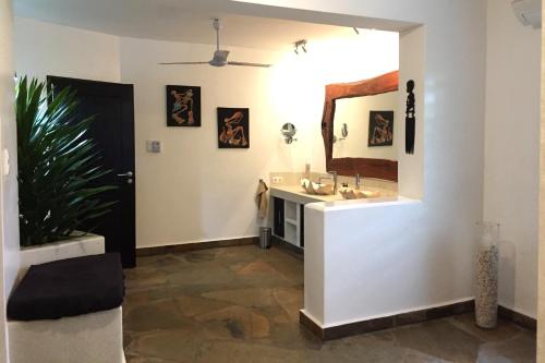 迪亚尼海滩Galu Backpackers & Ecolodge的一间带水槽和镜子的浴室