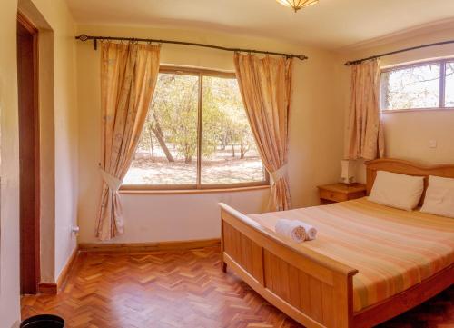 奈瓦沙Ol-Kine Cottage at The Great Rift Valley Lodge & Golf Resort Naivasha的一间卧室设有一张床和一个大窗户