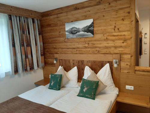 萨尔茨堡波尔瓦恩旅馆的一间卧室配有带白色床单和绿色枕头的床。