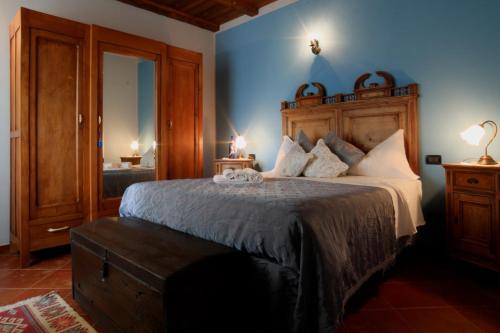 BubbioTre colline in langa的一间卧室配有一张大床和木制床头板