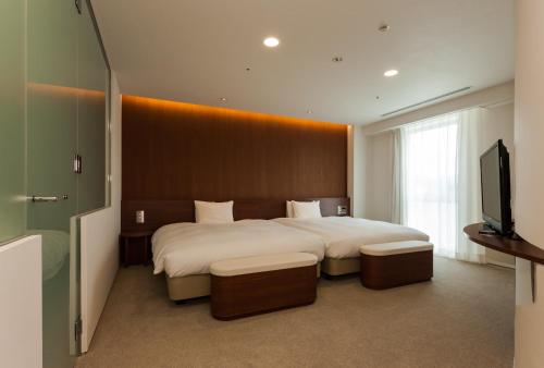 沼津沼津大和鲁内酒店的一间卧室配有一张大床和一台平面电视