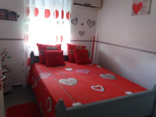 拉芒坦Villa Bananier的一间卧室,配有红色的床,上面有心