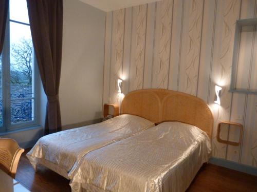 Saint-Boil白马之餐厅酒店的一间卧室配有一张带两个灯的床