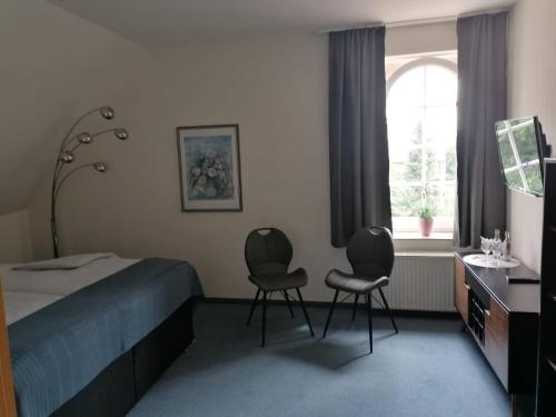 瓦伦多夫Gasthof-Hotel Biedendieck的一间卧室配有两把椅子、一张床和窗户