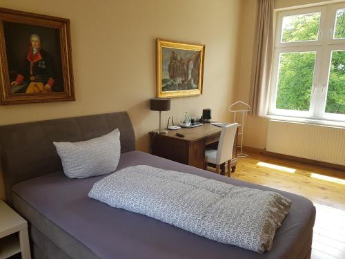 吕登沙伊德Schillers Hotel & Café - GARNI -的一间卧室配有一张床和一张书桌