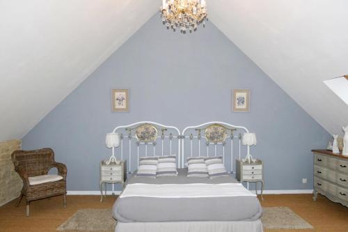 Saint-Vigor-le-GrandLes Pérelles的一间卧室配有一张床和一个吊灯