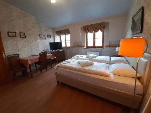 克拉科夫卡齐米秘密酒店的一间卧室配有一张大床和一张桌子及椅子