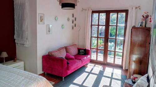 丰沙尔La Chambre de Ker Briac的客厅配有粉红色的沙发和床。