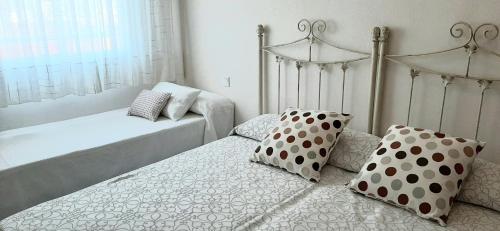 塞维利亚Apartamento Realengo Sevilla的卧室内的两张床和波卡圆顶枕头