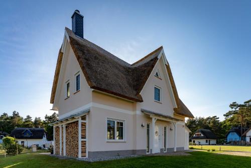 ZirchowLuxusferienhaus Fuchsbau - mit Netflix, PlayStation, Sauna, Sportraum und Kamin的黑色屋顶的白色房子